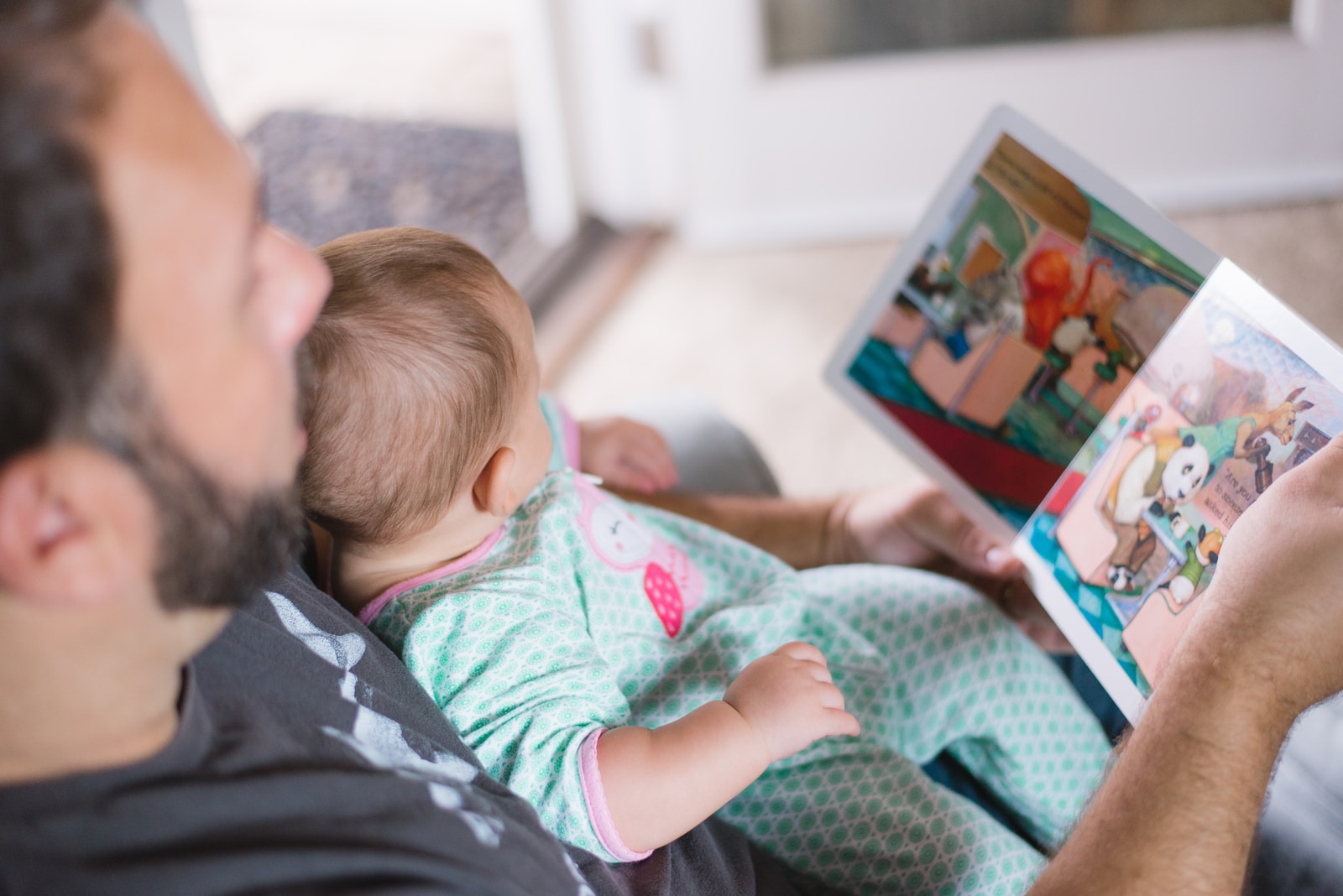 Homme en train de lire à un bébé
